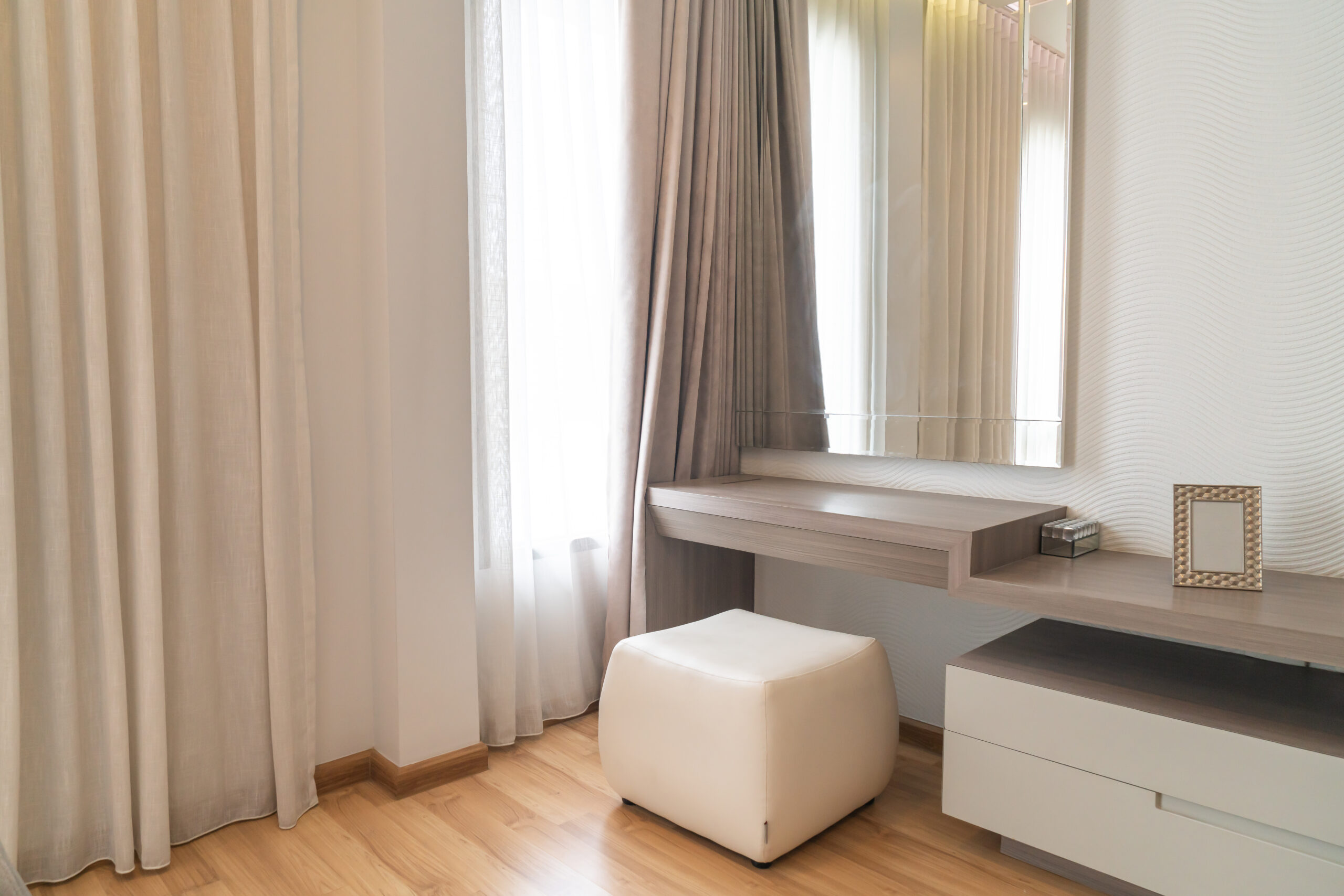 empty dressing table with mirror and curtain in bedroom